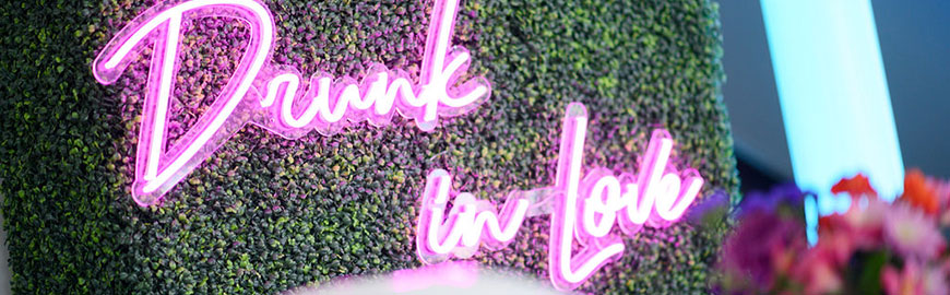 Boxwood Hedge with "Drunk in Love" pink neon sign